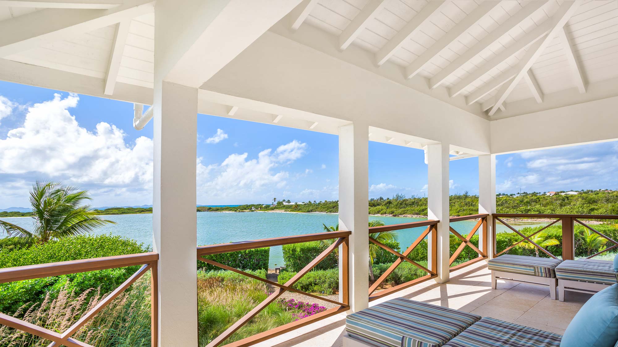 Terrace seating area with timber railing and uninterrupted pond views